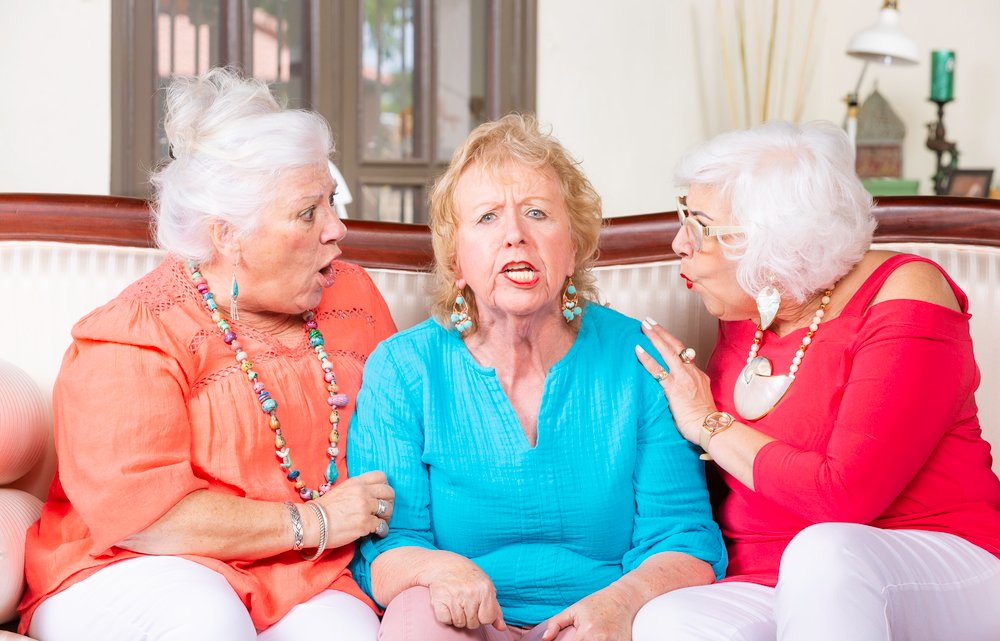 Two senior ladies reacting to their angry friend