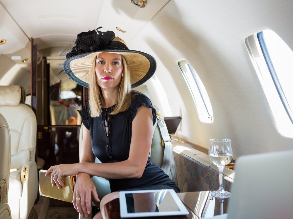 Portrait of confident rich woman sitting in private jet