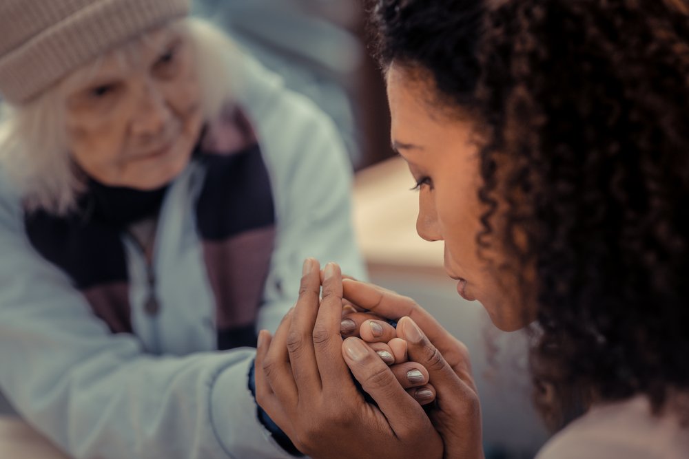 So thankful. Sad homeless woman looking at her helper while being thankful to her