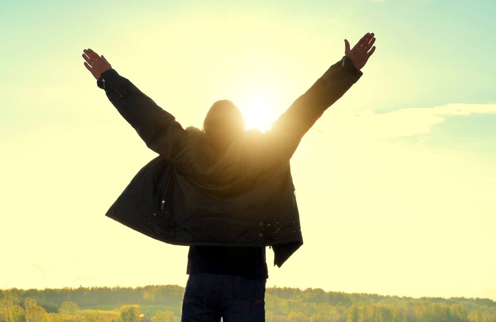 Happy Man Silhouette with Hands Up on the Nature Background