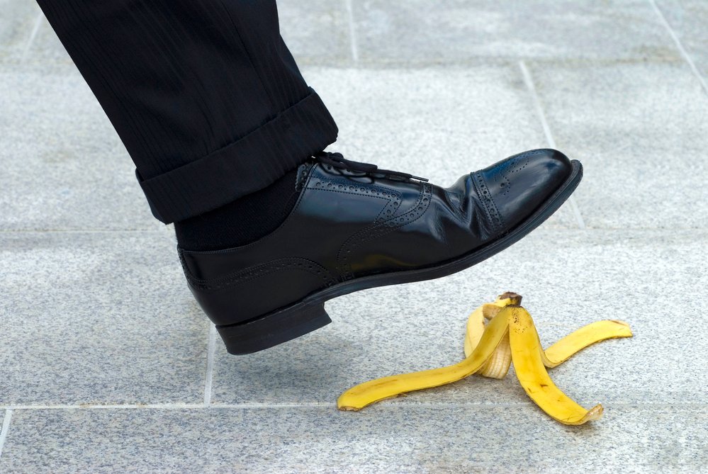 Businessman stepping on banana skin