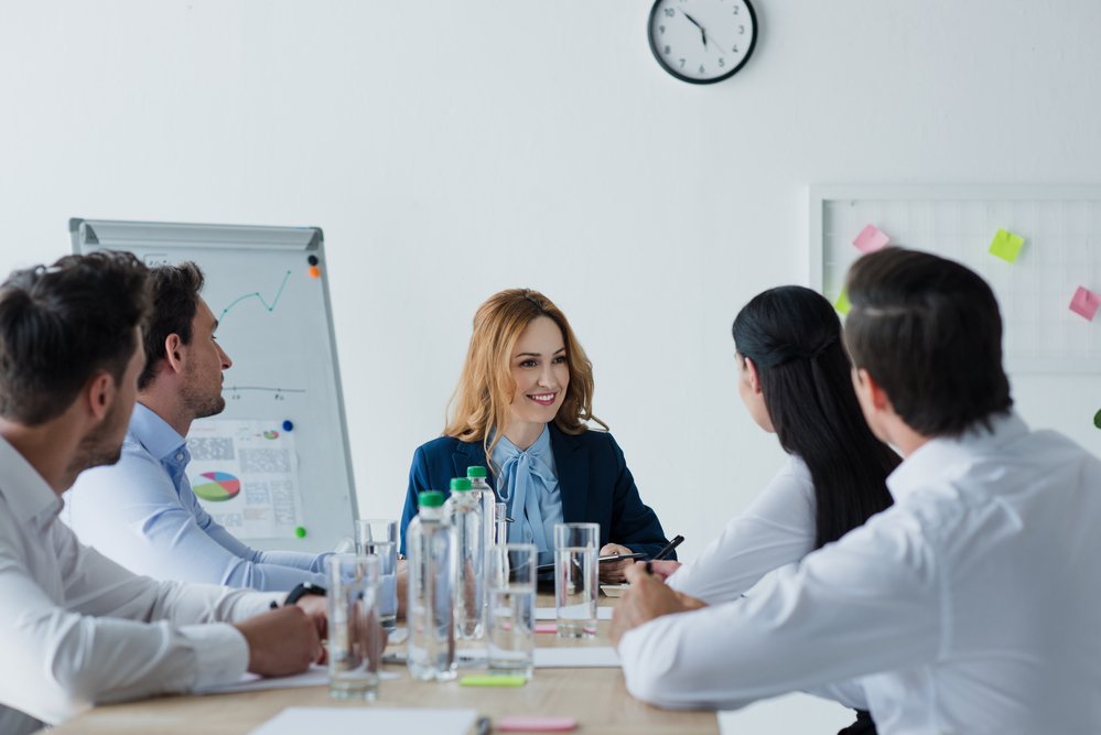 Partial view of business colleagues having discussion at workplace in office