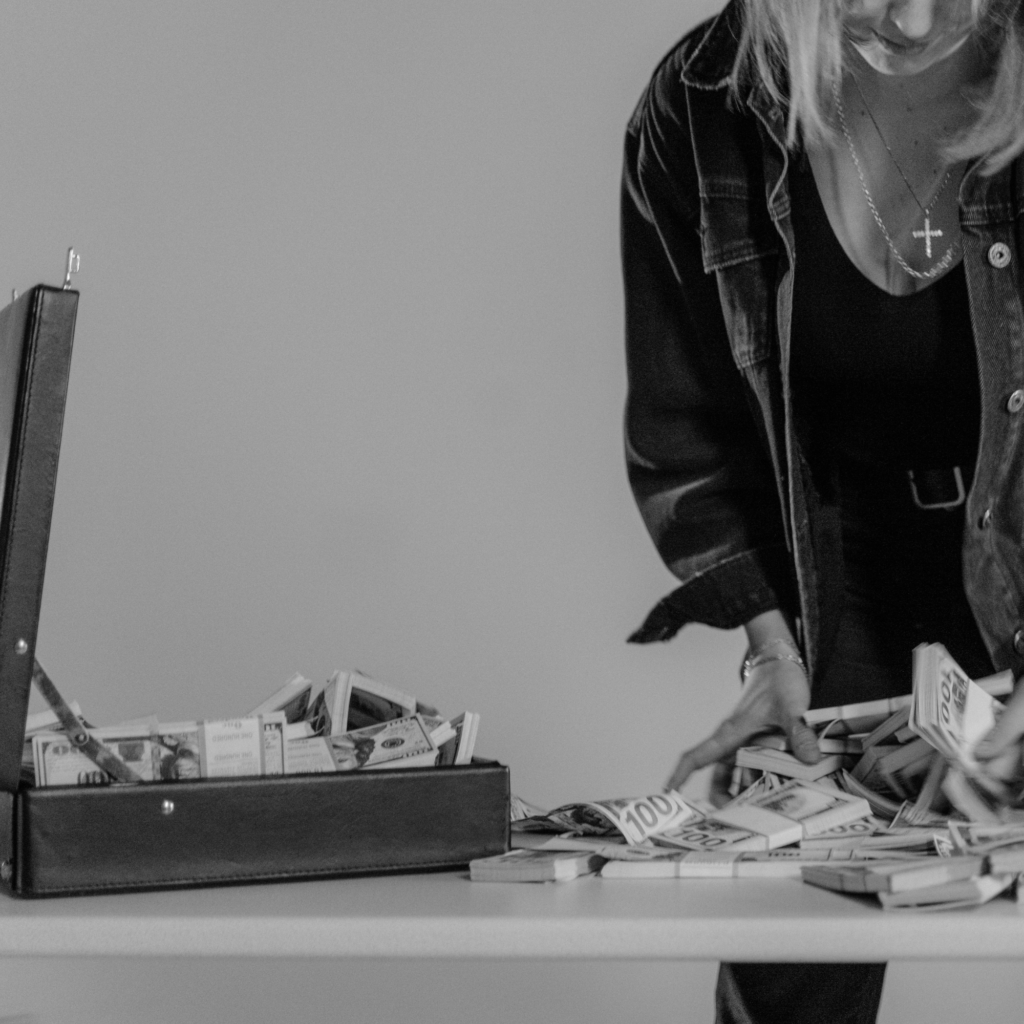 woman collecting money into an open briefcase