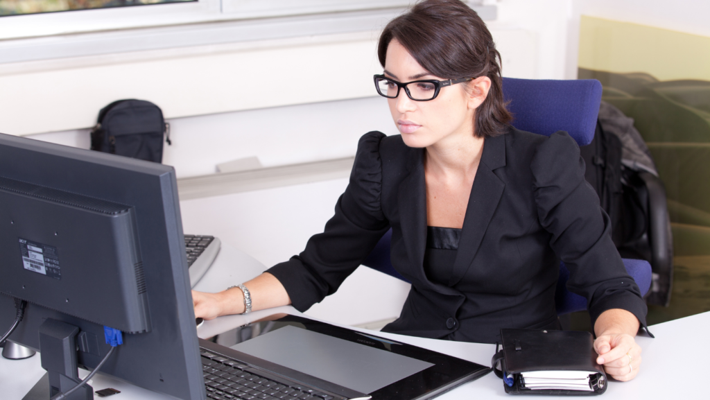 woman working on a computer looking serious wearing glasses