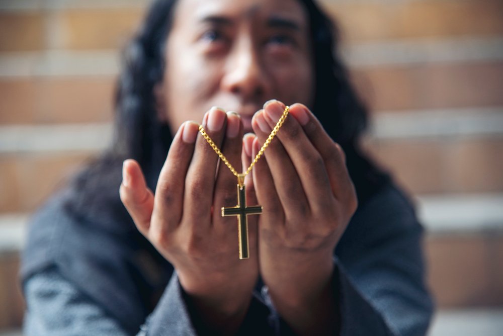 Homeless man praying to god for help people poverty beggar man asking for money job and hoping help in helpless dirty city sitting on street. Close up hands of homeless man praying beggar in city life