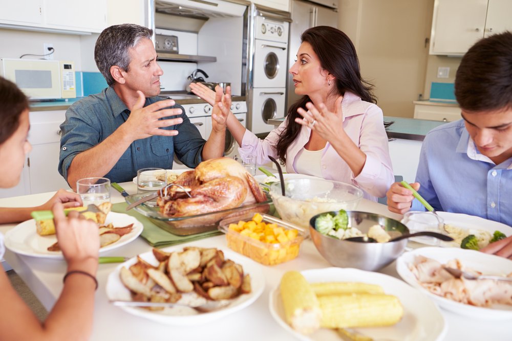 Family Having Argument Sitting Around Table Eating Meal