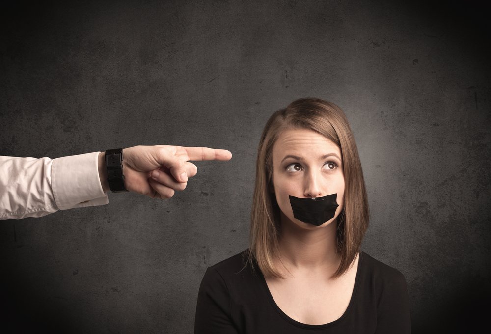 Caucasian business hand pointing at female employee with grunge background