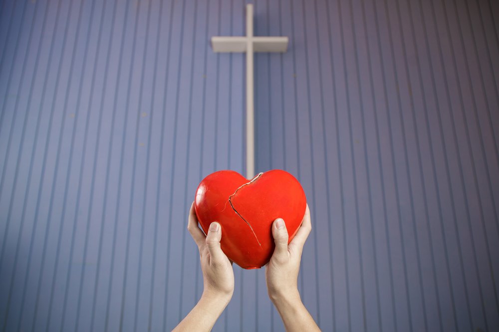 Surrendering broken heart to the cross, conceptual Christian photo