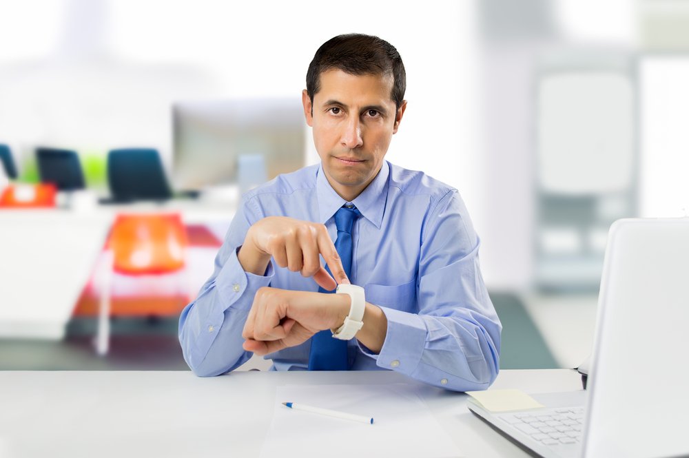 businessman angry and pointing his watch as concept of arrive late at the work